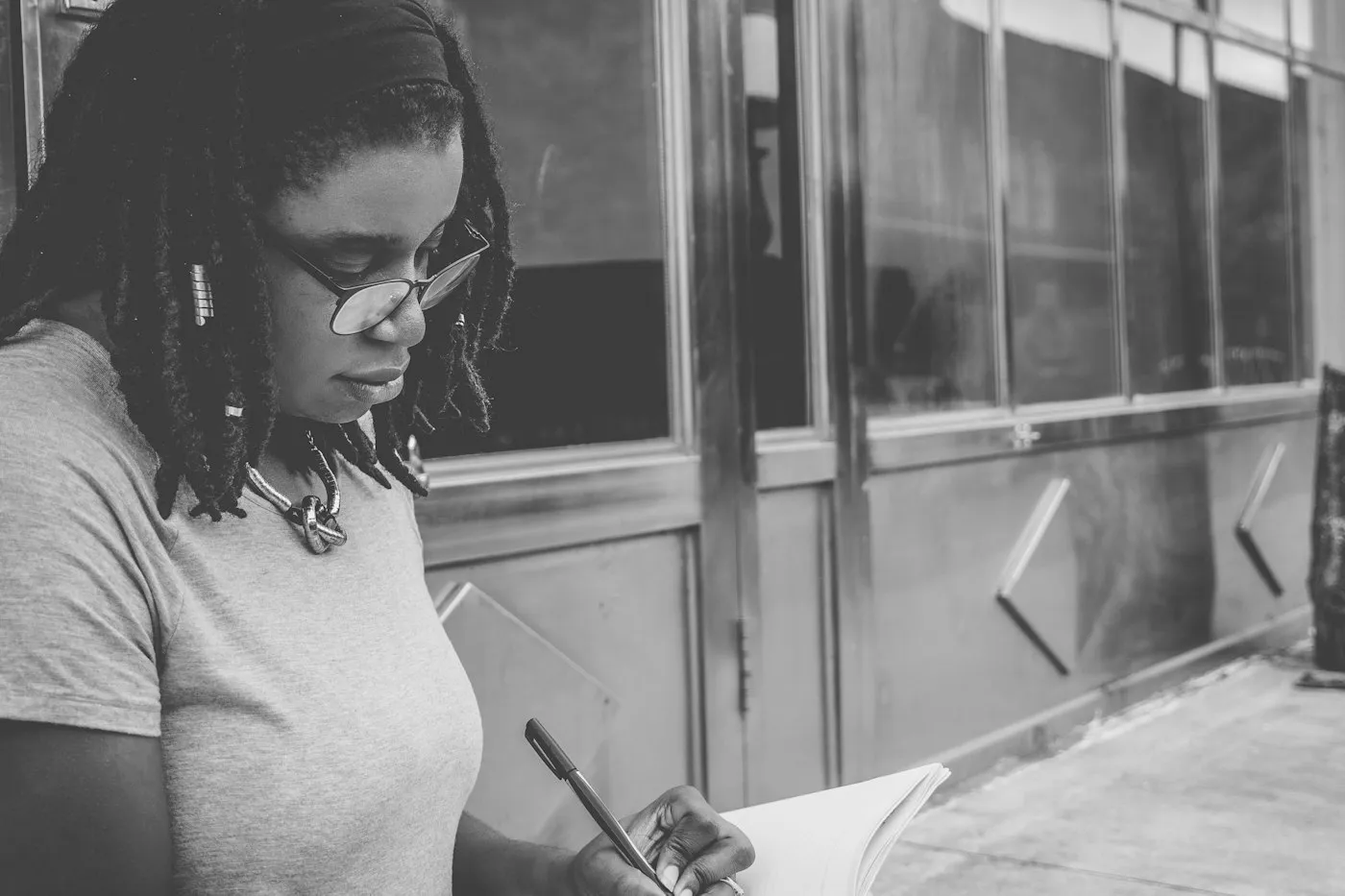 Mujer escribiendo y revisando papeles, fotografía en blanco y negro